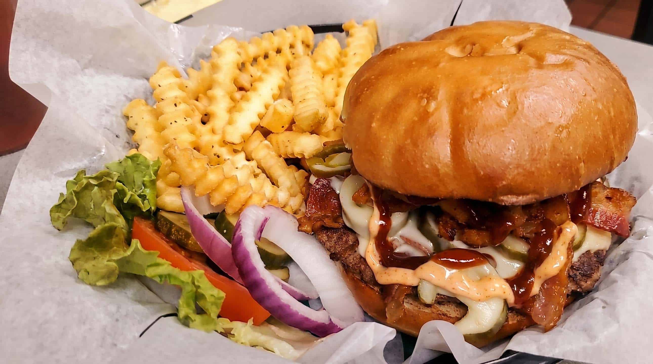 Loaded specialty burger with bacon, cheese and crinkle-cut fries