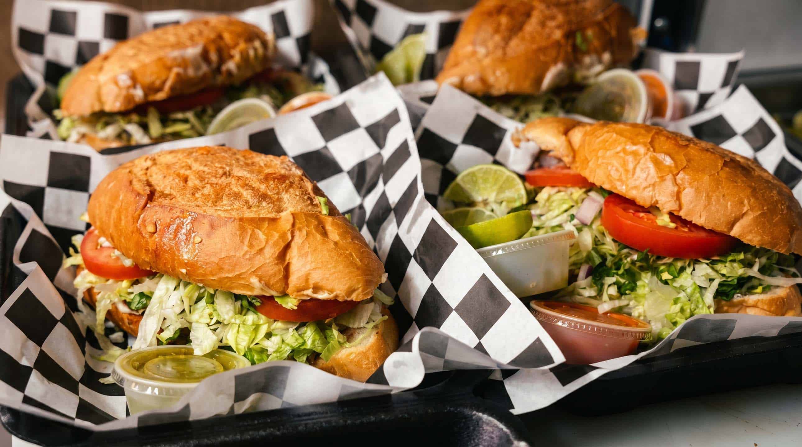 Mexican tortas filled with beans, avocado, lettuce and tomato